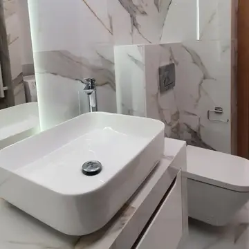 Nowoczesna łazienka z umywalką nablatową, marmurowymi płytkami i zabudowaną toaletą